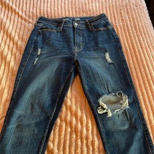 Extra high-rise. 360 stretch. Dark wash. Distressed jean